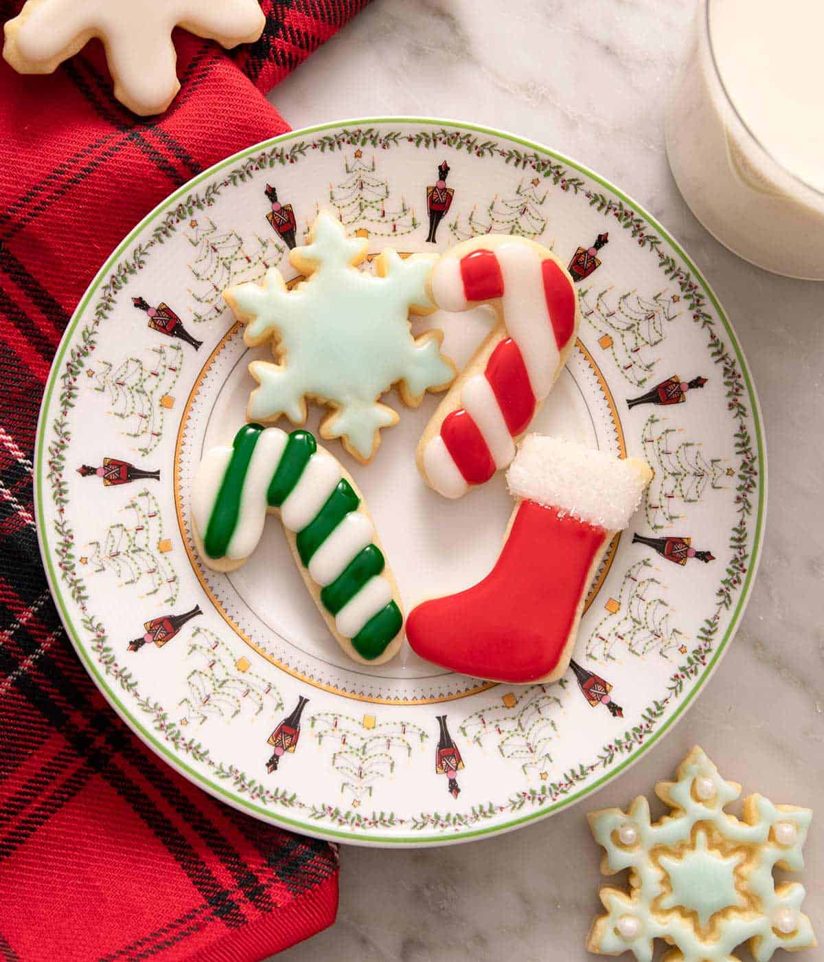 An overhead shot of a plate of Christmas sugar cookies with colored icing