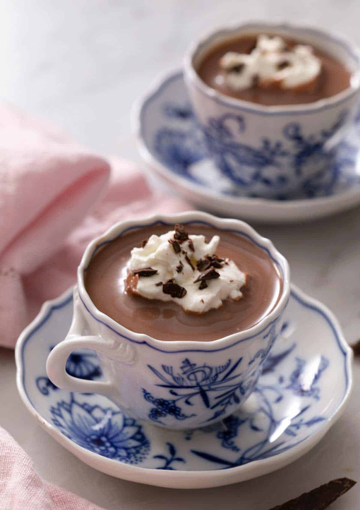 A blue china cup of hot chocolate. A second cup in the background.
