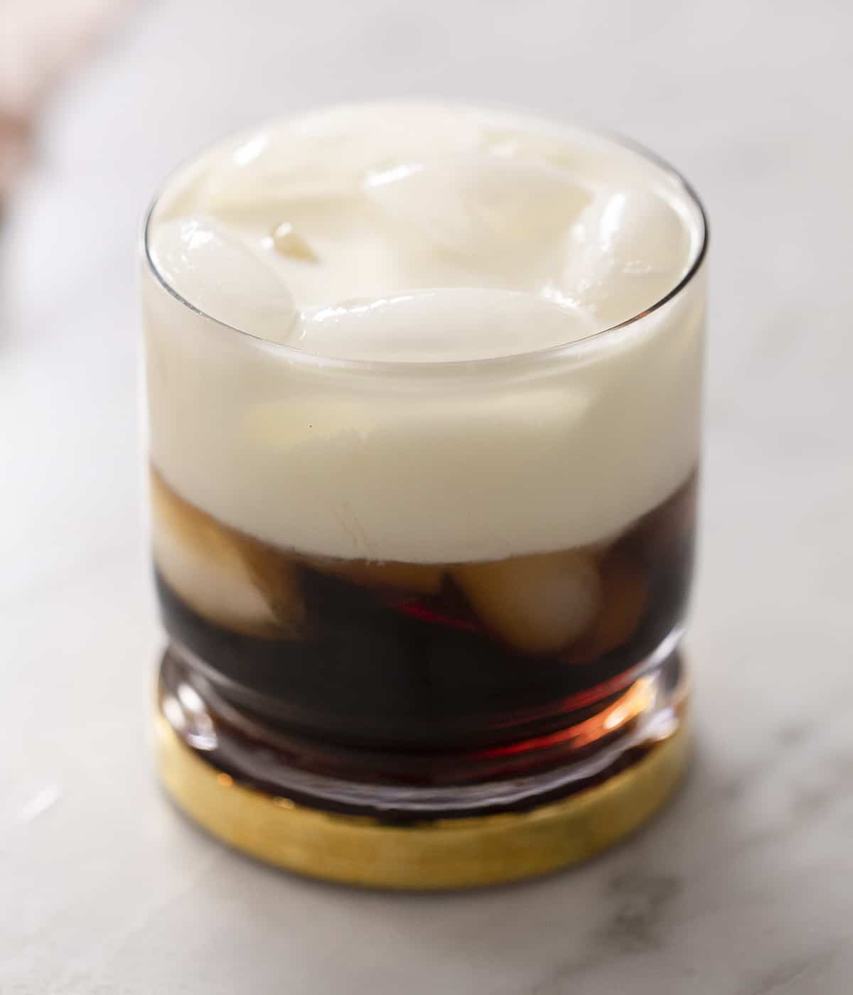 A close up of a White Russian cocktail in a glass filled with ice