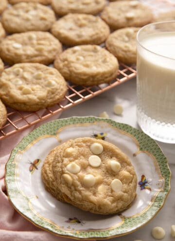 White chocolate chip cookies on a small plate and some on a cooling rack