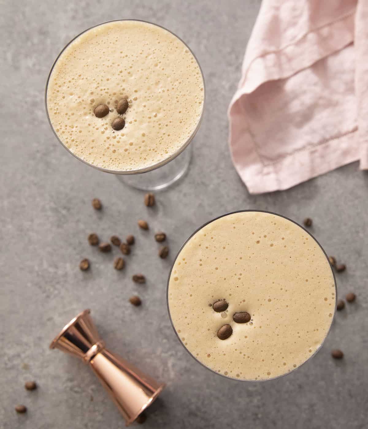 An overhead shot of two espresso martinis topped with coffee beans.