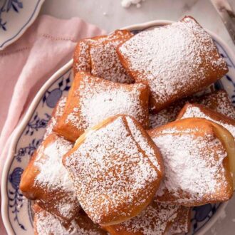 Pinterest graphic of an overhead shot of a platter of homemade beignets.