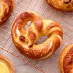 A close up of a soft pretzel on a cooling rack