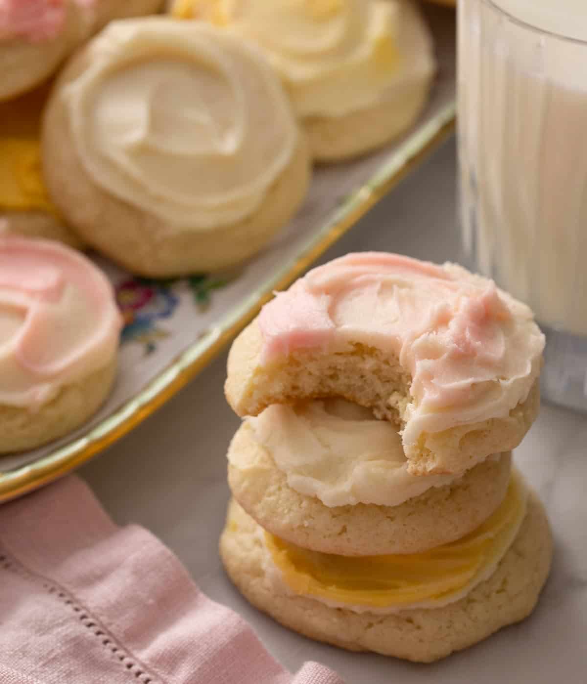Sour cream cookies stacked on top of each other and one with a bite out