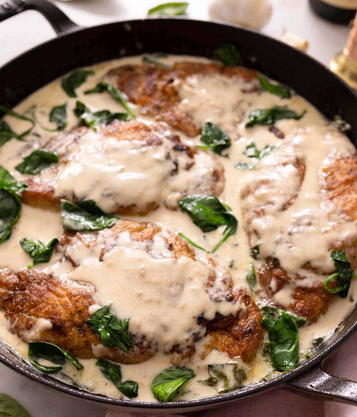 Close up of a braiser containing chicken florentine.