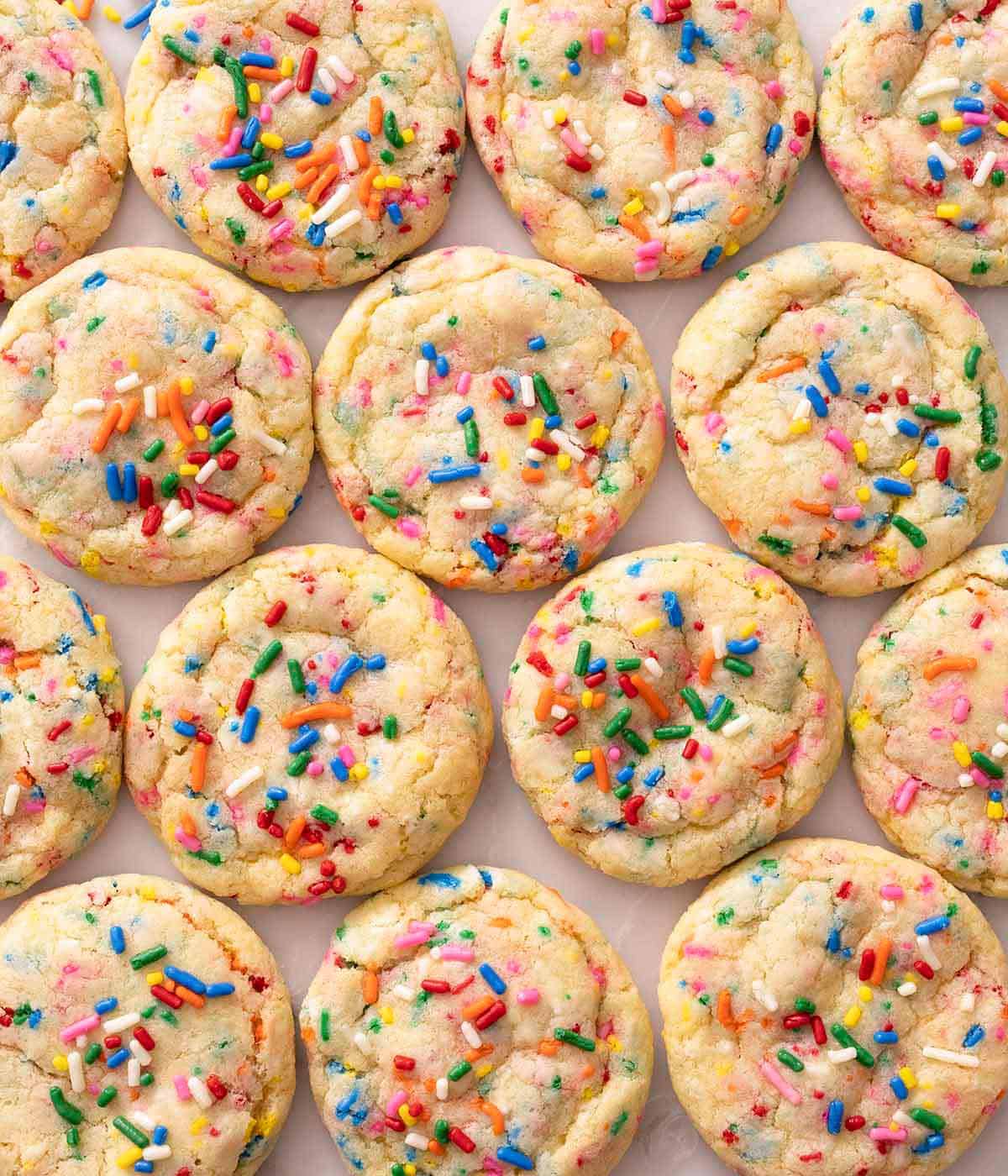 Multiple funfetti cookies with extra sprinkles on top laid out in a grid.