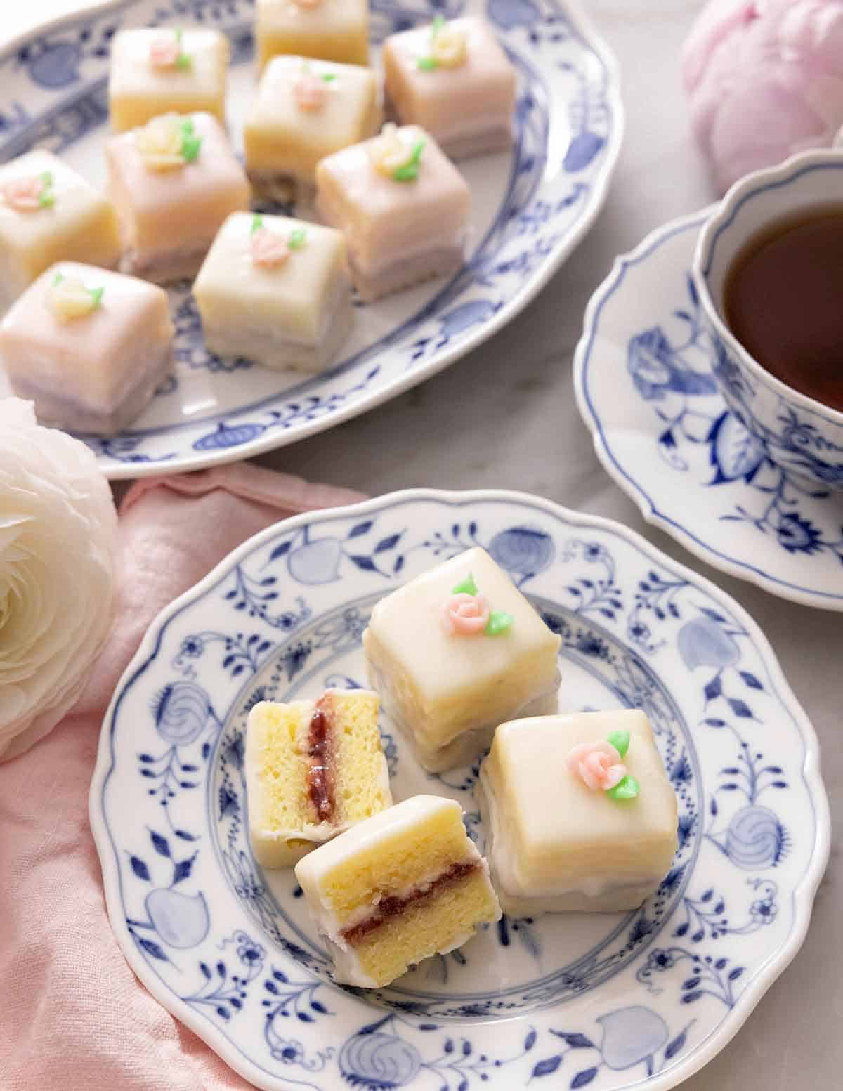 Overhead view of two plates of petit fours with one cut opened in half.