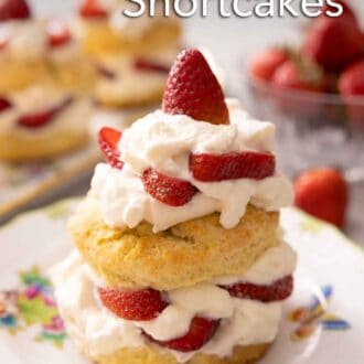 Pinterest graphic of an individual strawberry shortcake with whipped cream and strawberries in front of a bowl of berries and more shortcakes.