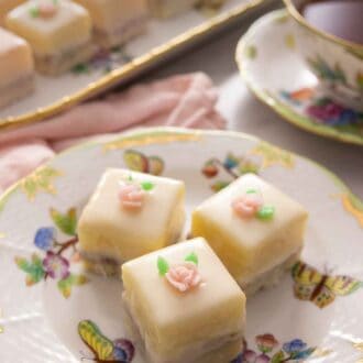 Pinterest graphic of a close up of three petit fours on a plate beside a cup of tea.