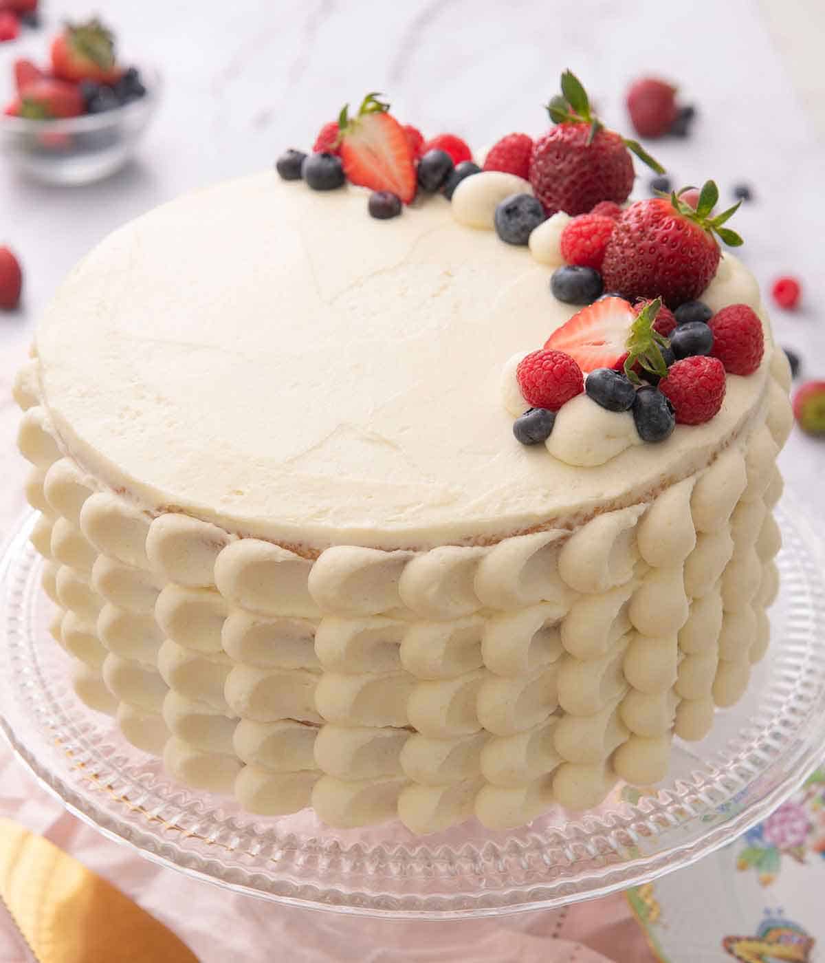 A Chantilly cake with fresh berries right aligned on the cake's top.