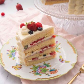 Pinterest graphic of a slice of Chantilly cake showing the layers and berries in the cream filling.