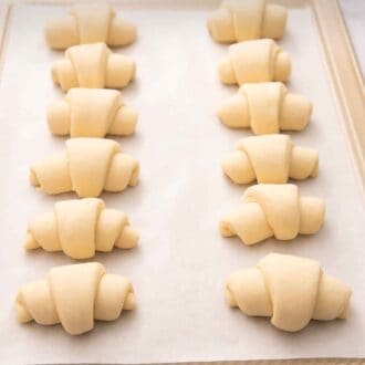 Pinterest graphic of crescent roll recipe on a sheet pan before baking.