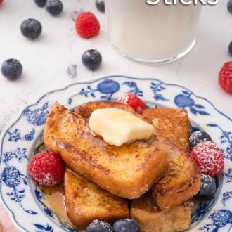 Pinterest graphic of a plate of French toast sticks with a knob of butter on top and with fresh berries beside them on the plate. A glass of milk and additional berries are in the background.
