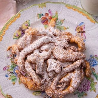 Pinterest graphic of an overhead view of a funnel cake on a plate with butterflies on it.