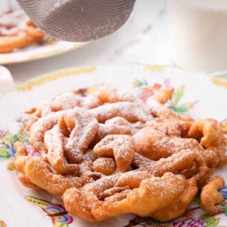Pinterest graphic of powdered sugar being dusted onto a funnel cake.