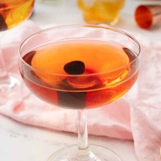 Pinterest graphic of a glass of Manhattan with a maraschino cherry in the middle.