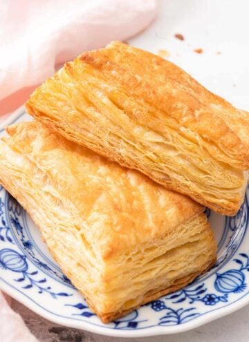 A blue and white plate with two puff pastries.