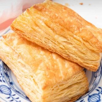 Pinterest graphic of two pieces of puff pastries on a white and blue plate.
