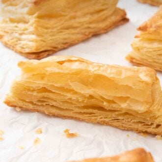 Pinterest graphic of a few puff pastries with one cut in half, showing the layers.