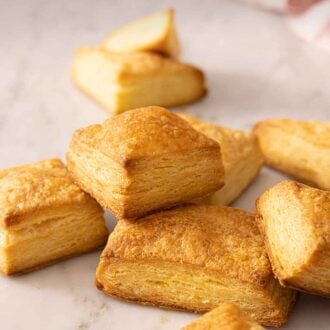 Pinterest graphic of a pile of puff pastries on a marble surface.