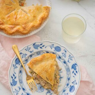 Pinterest graphic of a plate of turkey pot pie beside the cut pie over top of a pink linen napkin.