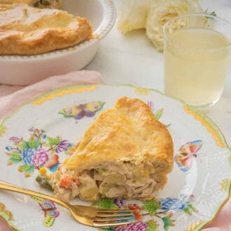Pinterest graphic of a serving of turkey pot pie on a plate on top of a pink linen, beside a drink and the rest of the pie in the pie dish.