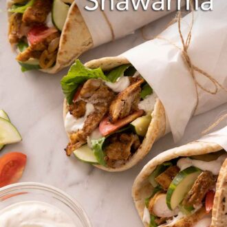 Pinterest graphic of three chicken shawarma with parchment paper wrapping them up.