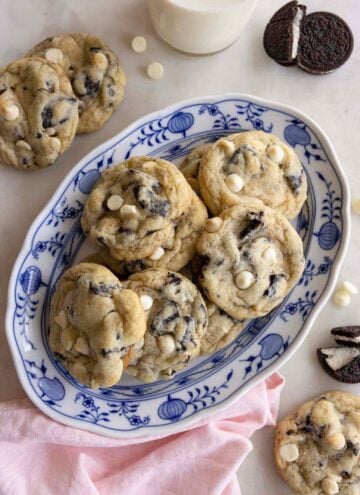 Overhead view of an oval platter of cookies and cream cookies with a couple scattered around it with oreos.
