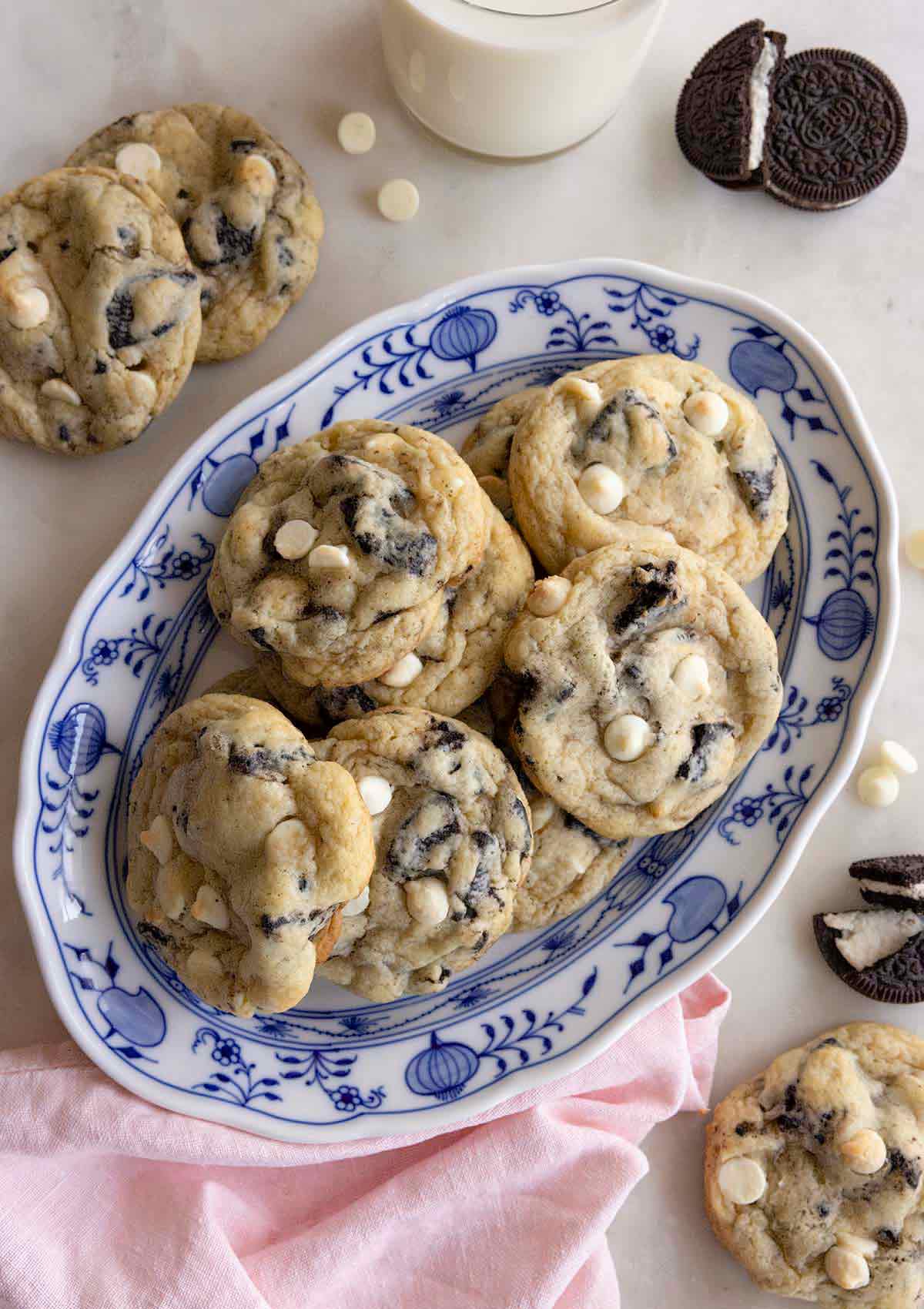 Overhead view of an oval platter of cookies and cream cookies with a couple scattered around it with oreos.