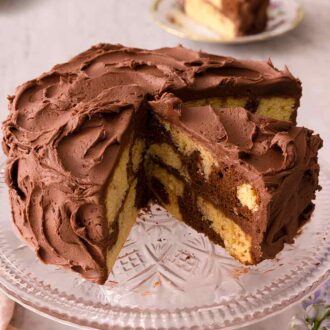Pinterest graphic of a cake stand with a cut marble cake on top. One cut slice is on the stand still and the other on plates in the background.