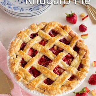 Pinterest graphic of a strawberry rhubarb pie with fresh strawberries and rhubarb scattered around it with a stack of plates and forks to the side.