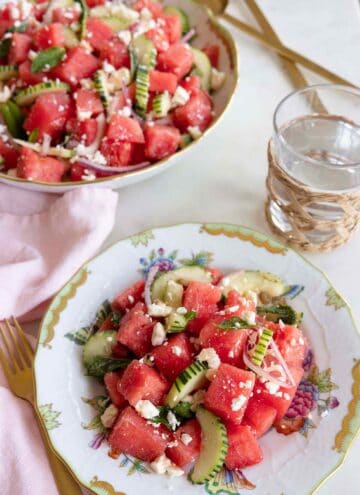 A plate of watermelon salad beside a glass of water and a bowl of watermelon salad.