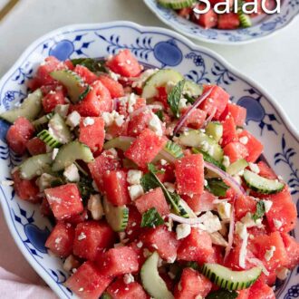 Pinterest graphic of an oval platter of watermelon salad with a small plate beside it.