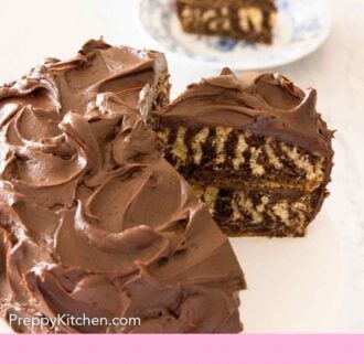 Pinterest graphic of a cut zebra cake with one slice still on the cake stand and one slice on a plate in the background.