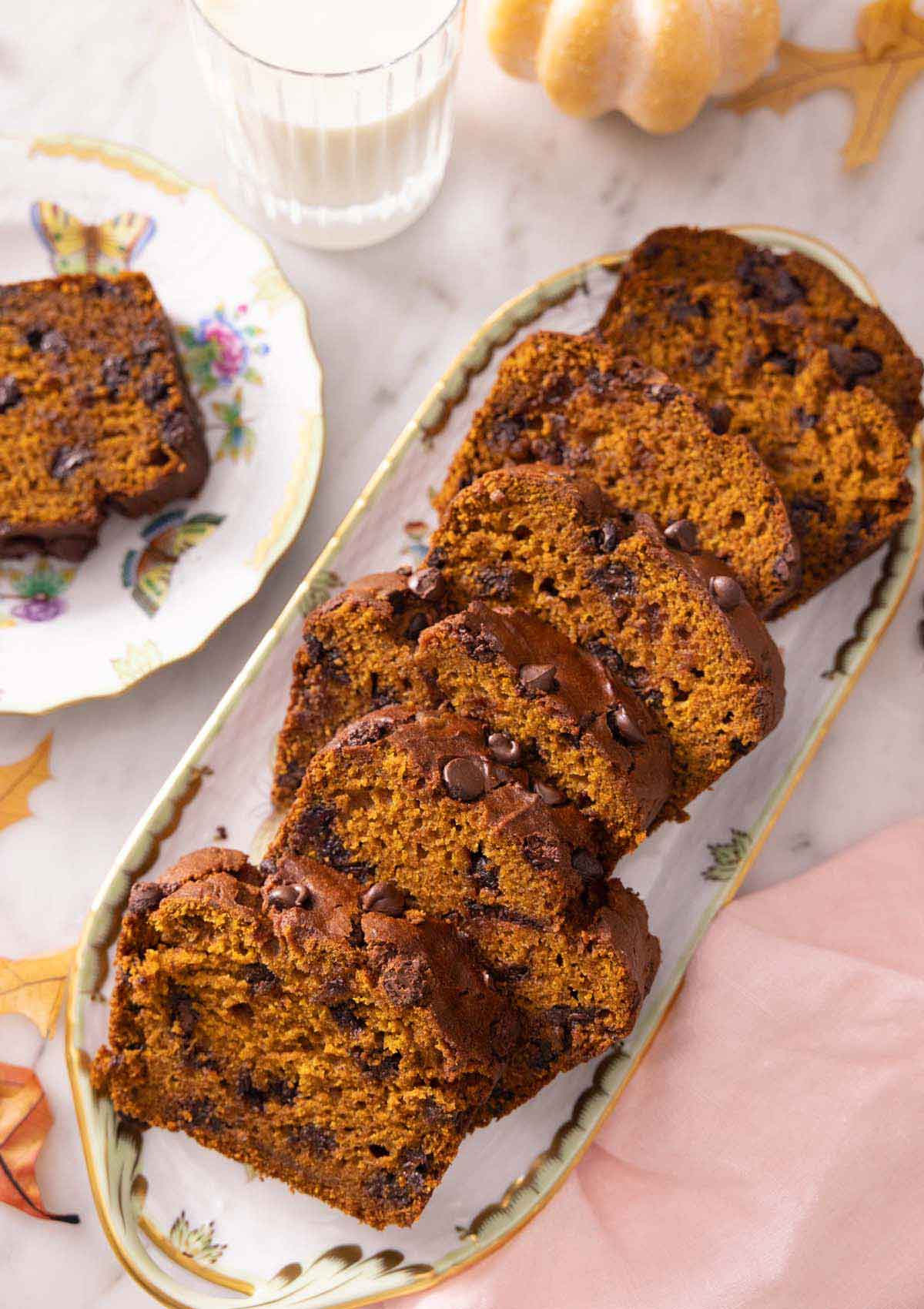 A serving platter with sliced chocolate chip pumpkin bread.