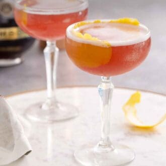 Pinterest graphic of two glasses of French martinis on a marble serving tray.