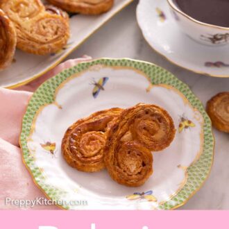 Pinterest graphic of a plate of palmiers with a platter of more in the back by a cup of coffee.