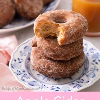 Pinterest graphic of a stack of three apple cider donuts on a plate, the top on with a bite taken out of it.