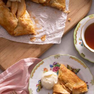 Overhead view of a plate of a slice of apple galette with a scoop of ice cream beside the rest of the galette.