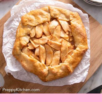 Pinterest graphic of an overhead view of an apple galette on a sheet of parchment paper on a wooden serving board.