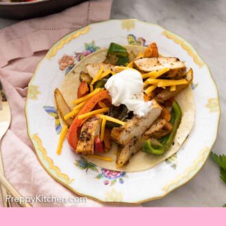 Pinterest graphic of a plate of chicken fajitas on a tortilla.