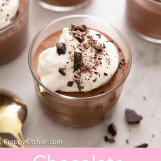 Pinterest graphic of a chocolate mousse topped with whipped cream and chocolate shavings. Three more chocolate mousses in the background, out of focus.