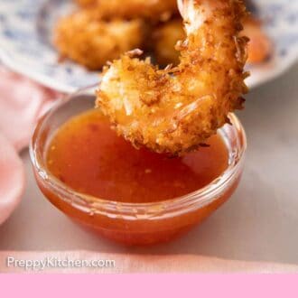 Pinterest graphic of a small bowl of sweet chili sauce with a coconut shrimp about to be dipped into it.