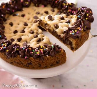 Pinterest graphic of a cookie cake on a cake stand with a slice lifted out.