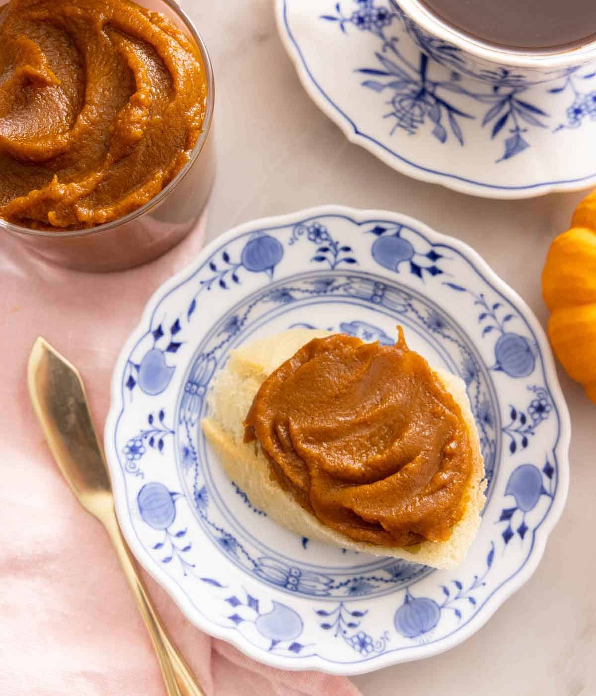 Overhead view of a plate with a piece of bread with pumpkin butter spread on top.
