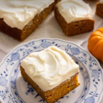 Pinterest graphic of a square slice of pumpkin cake on a plate with the rest of the cake in the background.