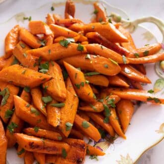 Pinterest graphic of a platter of roasted carrots with chopped parsley.