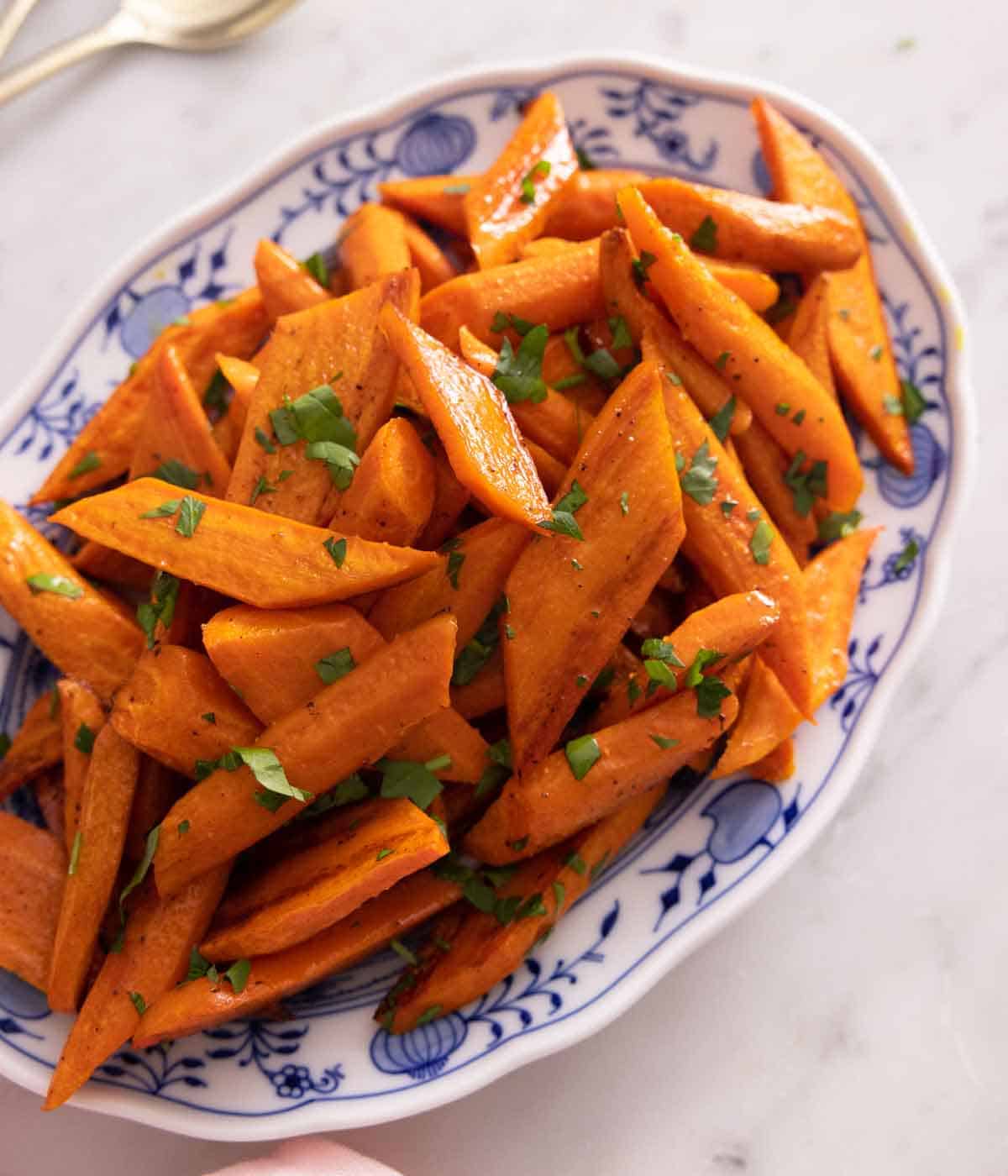 A platter of cut carrots that were roasted in the oven.