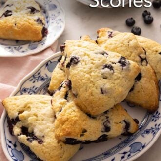 Pinterest graphic of a platter of blueberry scones with a plate with a single scone in the background.