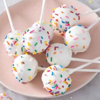 A plate of cake pops with sprinkles scattered around.